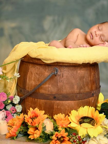 A full view of the bucket pose, showing the beautiful arrangement of sunflowers and other props that create a warm, rustic scene.