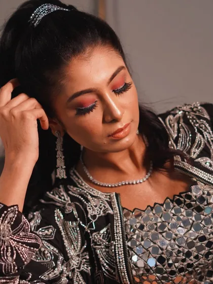 A close-up on the vibrant eye makeup. The pop of red on the lower lash line adds an unexpected and creative touch to this party look.