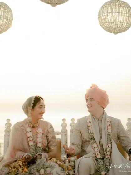 A candid, happy conversation between the bride and groom at their beachside mandap, their smiles telling a story of love and excitement.