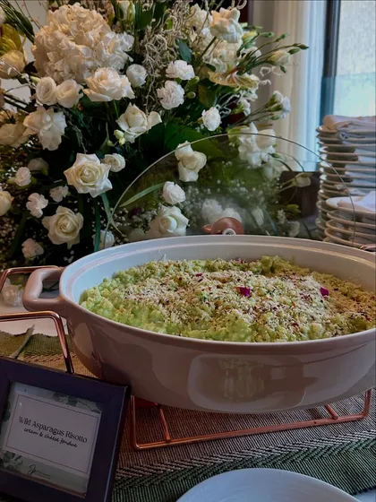 A large serving dish of our Wild Asparagus Risotto, creamy and delicious, ready for guests to enjoy.