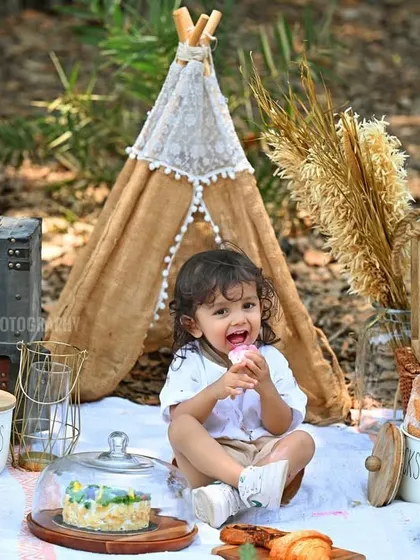 A fun picnic-themed kid's photoshoot, with the little one enjoying some treats in a beautiful outdoor setting.