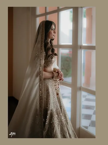 A quiet moment of reflection for the bride, Ishita, before her Jodhpur wedding. The soft window light and her elegant Arpita Mehta lehenga create a timeless and graceful bridal portrait.