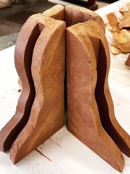 The raw, unglazed terracotta forms for the 'Confrontation' piece, showing the structure before the illustrative details were added.