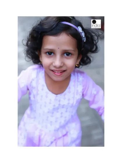 A candid shot filled with energy and movement. The slight blur and her direct gaze create a dynamic and engaging portrait that captures the feeling of being a happy, active child.