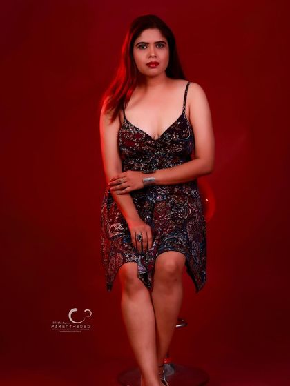 A confident seated pose on a stool. The composition is classic, and her expression is poised and direct.