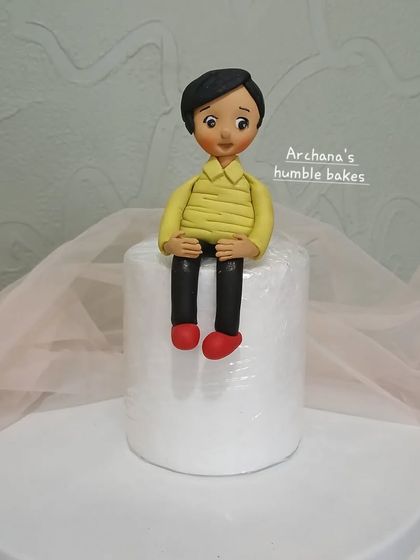 A clear, full shot of the cute boy figurine made from fondant.