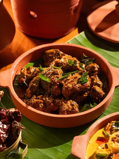A dry chicken dish, also served in terracotta, suggesting a traditional cooking method.