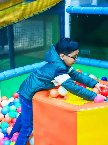 A young party guest fully engaged with the colorful ball pit. Our birthday packages include unlimited access to all our play zones.