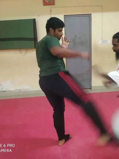 A student practices a kick while I block. One-on-one training is important for refining a student's specific techniques.