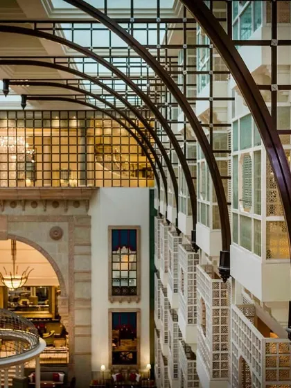 A creative architectural shot where the couple is seen through a window from afar. This "sneak peek" style of photo adds a sense of grandeur and context to their story.