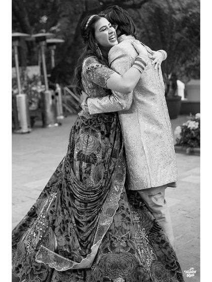A heartfelt hug between the bride and groom, captured in a timeless black and white photograph.