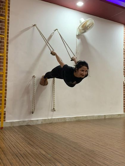 Flying high with rope yoga. This practice is not just about physical strength; it builds mental focus and trust in yourself. We are here to guide you on your journey.