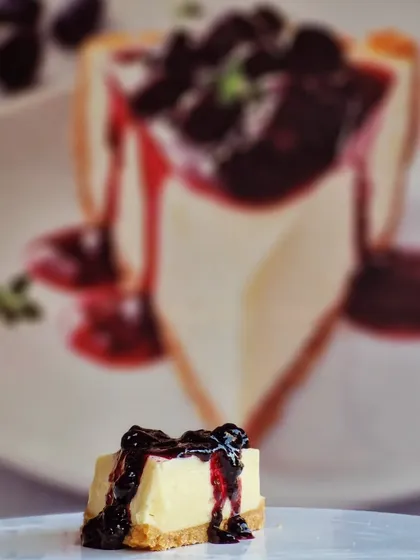 A slice of pure bliss. This is my classic Blueberry Cheesecake, featuring a creamy, rich cheesecake filling on a biscuit crust, generously topped with a tangy blueberry compote.