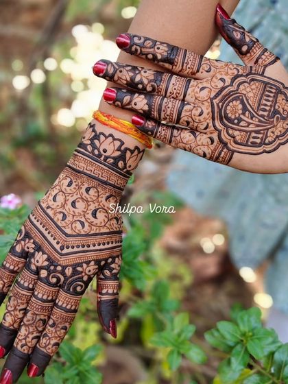 A shot showing two complementary back-of-hand designs, one with a V-shape and the other with a central motif.