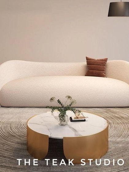 A beautiful example of a curved sofa in a textured bouclé fabric. This design, often called a "cloud sofa," offers a soft, organic shape that is both inviting and highly stylish, perfect for a modern, minimalist aesthetic.