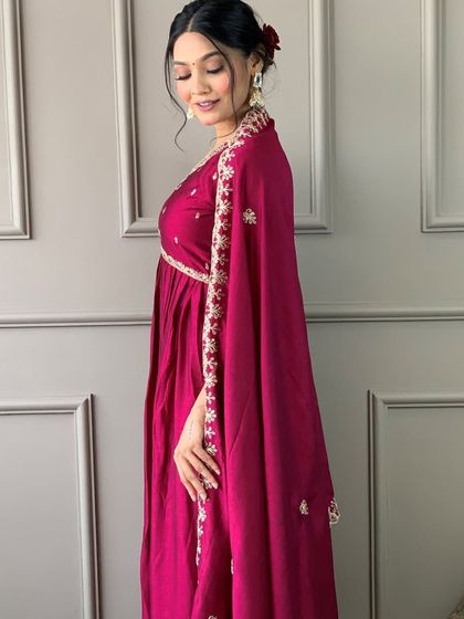 A rani pink kurta with an empire waistline. The heavy thread and sequin work on the yoke make it a flattering and festive choice.
