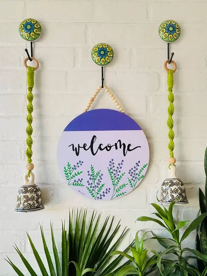 A beautiful wall setup featuring our 'Welcome' wooden sign and two green macrame ceramic bells. This combination creates a warm and inviting entrance, embodying the essence of handmade home decor.
