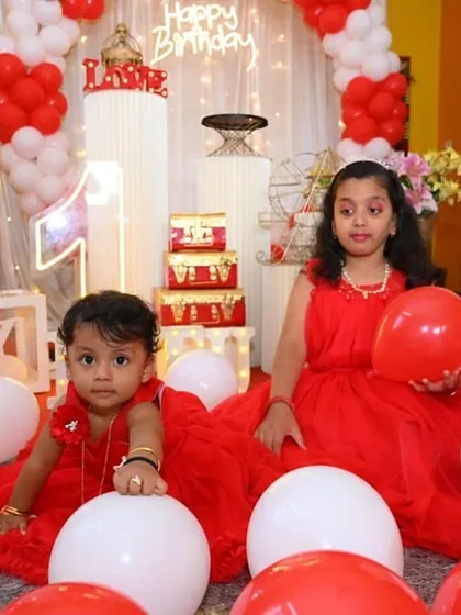 A classic and sweet red and white themed first birthday, with the birthday girl and her sister playing amongst the balloons and 'BABY' blocks.