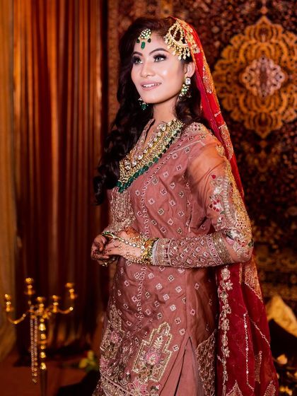 A side profile showcasing the elegant hairstyle and the way the dupatta is draped. Every detail is considered to create a harmonious and beautiful bridal look.