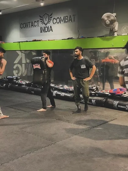 The entire class is engaged in pad work. This creates a high-energy environment where everyone is pushing themselves and each other to improve.