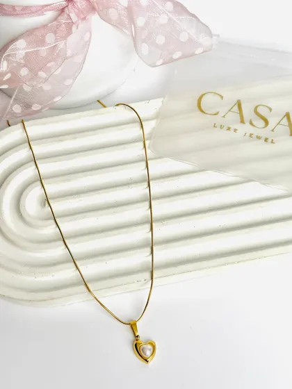 This heart and pearl pendant necklace is presented in a clean, minimalist style. This is a classic product shot, perfect for website listings and online marketplaces.