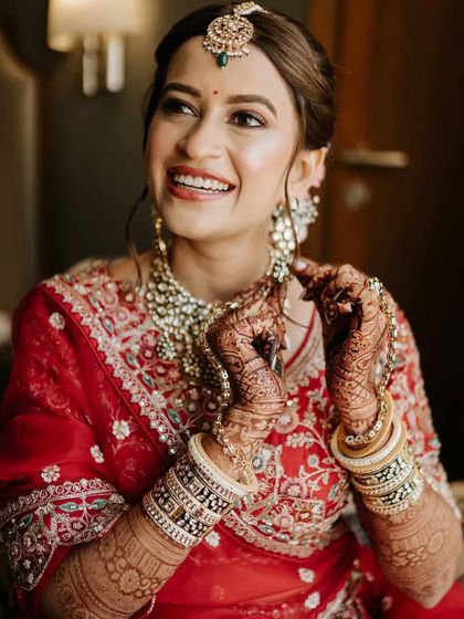 A radiant bride, getting ready for her big day. Her hands, adorned with my mehendi, are beautifully decorated with traditional bangles.