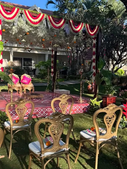 A closer view of a traditional Brahmin wedding mandap, showcasing the ornate chairs and festive decor under the bright sun.
