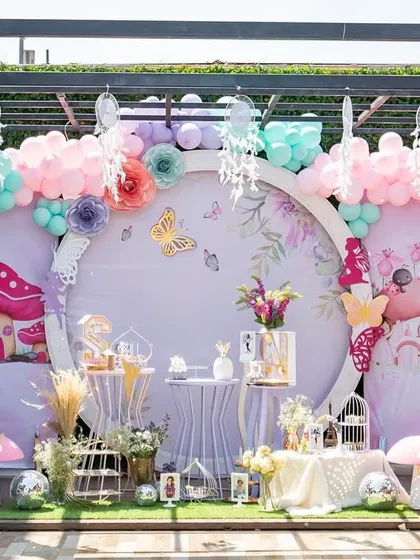 A beautiful pastel fairy-themed birthday setup for twins, featuring a circular backdrop, whimsical mushrooms, and dreamcatchers.