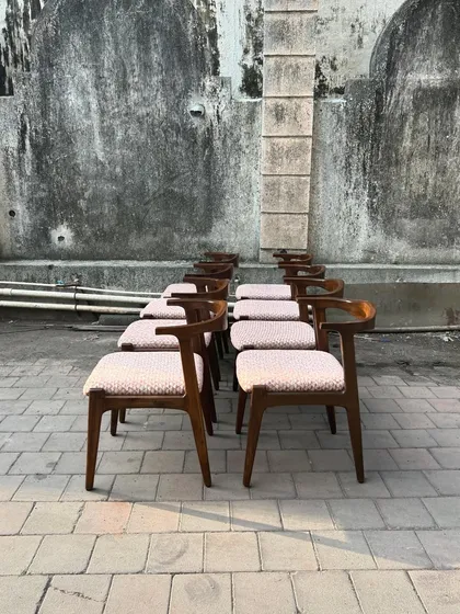 The dining chairs lined up, showing their elegant profile.