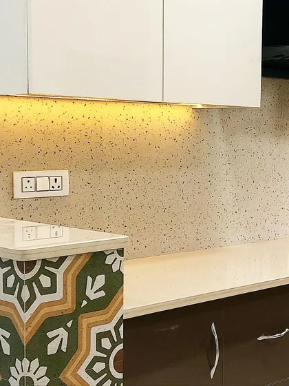 A before-and-after glimpse of this simple, earthy kitchen renovation. The patterned tiles on the side add a touch of personality to the otherwise neutral and warm space.