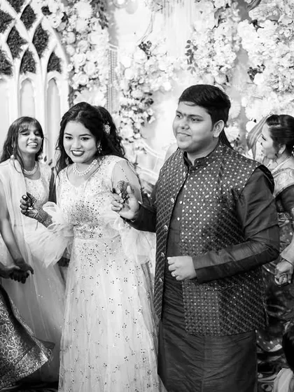 We converted this image to black and white to emphasize the emotion and energy of the moment. It captures the bride and groom enjoying the celebration, surrounded by the happy faces of their family, creating a timeless memory of the celebration.