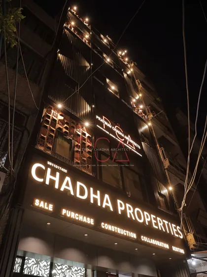 The facade of my firm's older real estate office, showcasing an elegant makeover with terracotta jaalis and ACP louvers. The illuminated signage and accent lighting create a distinguished presence at night, demonstrating my skill in commercial facade renovation.