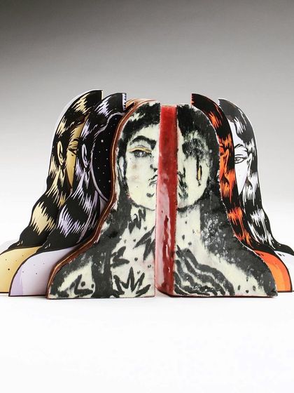 A frontal view of the assembled sculpture, highlighting the split face in the center.