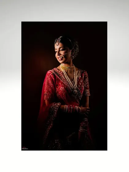 A beautiful, softly lit portrait of Divya. This shot captures her gentle smile and the intricate details of her bridal jewelry and attire.
