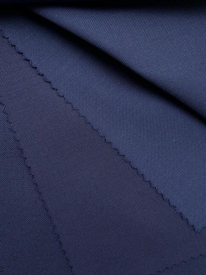 Layers of navy wool fabric, showing the different textures and weaves available for your custom suit.