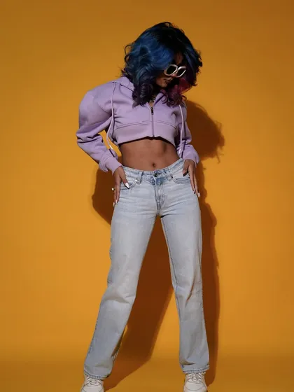 A full-length shot showcasing a casual, cool outfit against a bright yellow backdrop. The model's relaxed but confident pose perfectly captures the essence of modern, everyday style.