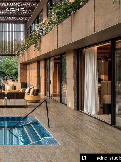 Beyond vertical spaces, we craft ground-level tropical sanctuaries. This villa's veranda flows directly to the poolside, with layered plantings and elegant bougainvillea creating a seamless transition between the built environment and the lush landscape.