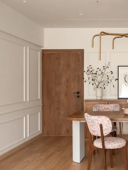 The dining area of "Apartment 222" is defined by its clean lines and natural materials. The wooden door and floors are complemented by the white paneled walls, creating a bright and airy feel.