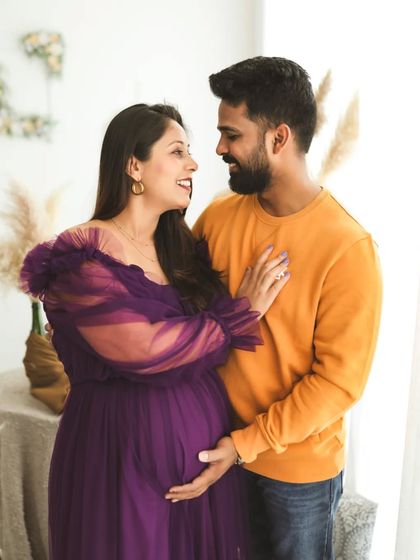 A proud mom-to-be, glowing with happiness. The way her partner looks at her is just so full of love and admiration. A beautiful, candid moment.