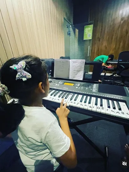 A young learner follows the notes labeled on the keys, a great method we use for beginners to help them get familiar with the keyboard layout.