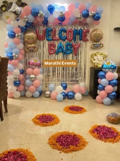 I also create joyful setups for non-religious celebrations like this "Welcome Baby" homecoming. This decoration combines a fun balloon arch in pink, blue, and silver with traditional marigold and rose petal rangolis on the floor.