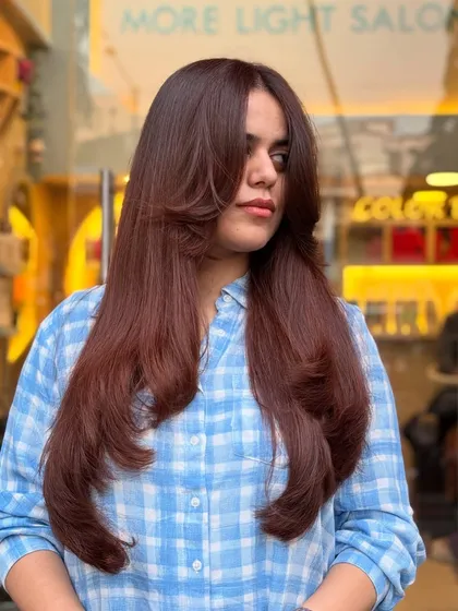 A global hair color in a copper and brown blend. This look makes a big statement with its rich, warm tones.