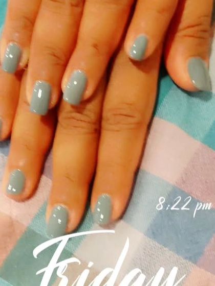A solid coat of muted grey-green polish on short, natural nails. This is a great example of a chic, modern neutral color that goes with everything.
