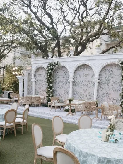 Another view of the European-inspired lounge area, showing the comfortable seating arrangements and the beautiful floral garlands accenting the architectural backdrop.