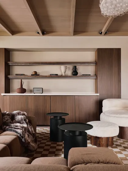 A view of the living room's built-in cabinetry and shelving. The clean lines, warm wood, and checkered flooring create a backdrop that is both stylish and functional, perfect for displaying curated objects.