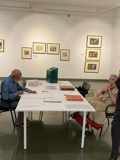 A candid shot of the artist and curator working at the library table.