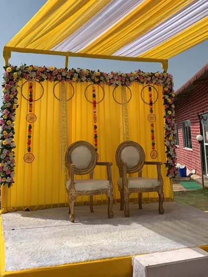 A full view of the simple and elegant outdoor Haldi stage. The raised platform and clean design make it a perfect spot for photos.