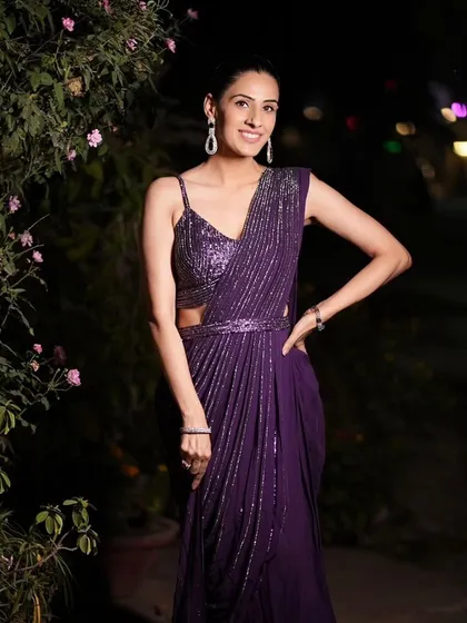 A full-length shot of the purple draped saree, showcasing its modern silhouette and sparkling details. Perfect for a cocktail party or reception.