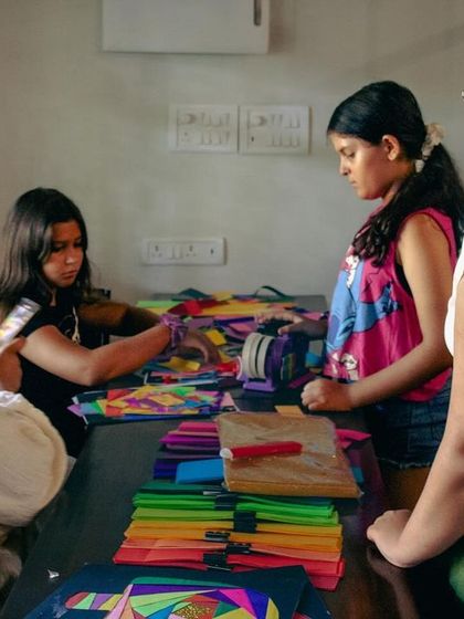Another shot from our successful Iris Folding collaboration. The table is covered in colorful paper as students work on their intricate designs.