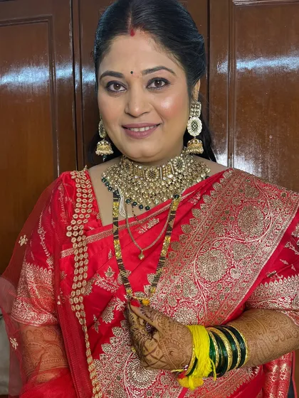 The bride adjusting her mangalsutra, a beautiful moment captured during her reception.